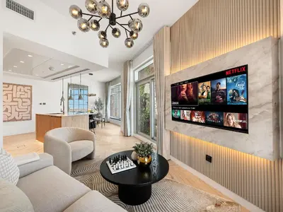 a living room with a tv on a wall at Kensington Stylish 1BR at The Lofts East Downtown in Dubai