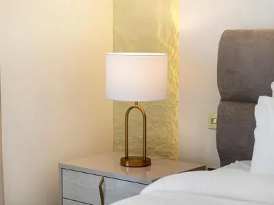 a lamp on a night stand next to a bed at Grande Signature Premium Stay in Dubai