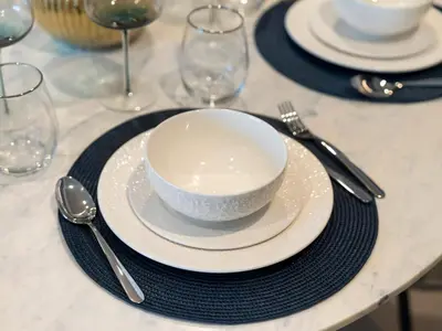 a white bowl on a plate on a table at Grande Signature Premium Stay in Dubai