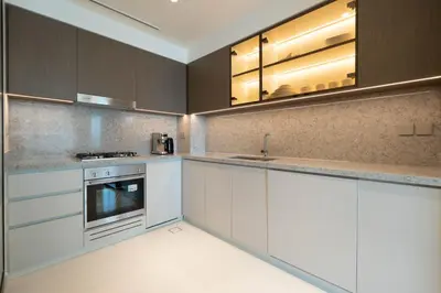 a kitchen with white cabinets and stainless steel appliances at KeyRock - Stylish 2BR Apt with Palm Jumeirah View, Balcony , Pool & Gym Access in Dubai