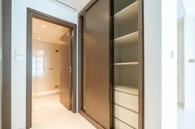 a walk in closet with a wooden door at KeyRock - Stylish 2BR Apt with Palm Jumeirah View, Balcony , Pool & Gym Access in Dubai