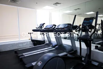 a gym with several tread machines in a room at Modern Studio 10 Mints Away From Expo Pool & Gym in Dubai