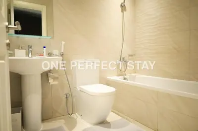 a bathroom with a toilet and a sink and a tub at Modern Studio 10 Mints Away From Expo Pool & Gym in Dubai