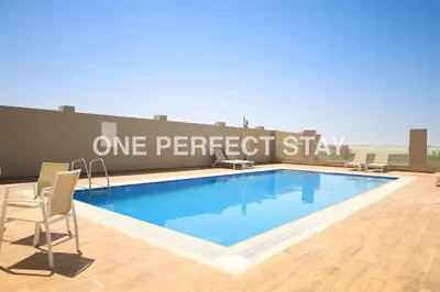 a swimming pool with chairs and a sign that reads one perfect stay at Modern Studio 10 Mints Away From Expo Pool & Gym in Dubai
