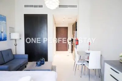 a living room with a couch and a table at Modern Studio 10 Mints Away From Expo Pool & Gym in Dubai