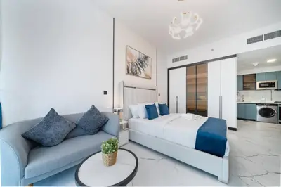 a bedroom with a bed and a couch at Modern and Spacious Studio Al Barsha South Stay in Dubai