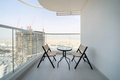 a table and two chairs in a room with a window at Modern and Spacious Studio Al Barsha South Stay in Dubai