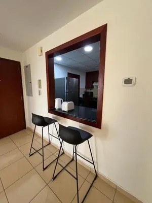 a mirror on a wall with two chairs in a room at JBR Skyview Rooms in Dubai