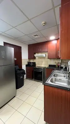 a kitchen with a stainless steel refrigerator and a sink at JBR Skyview Rooms in Dubai