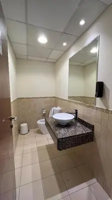 a bathroom with a sink and a toilet and a mirror at JBR Skyview Rooms in Dubai