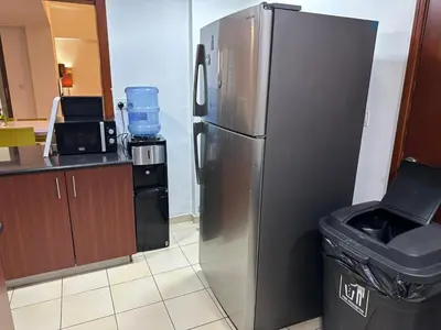 a stainless steel refrigerator in a kitchen with a trash can at JBR Skyview Rooms in Dubai