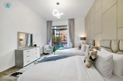 a white bedroom with two beds and a mirror at Furnished 2BR with Vibrant View in Dubai