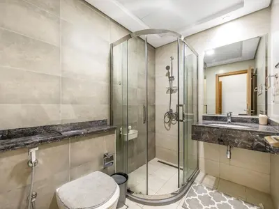 a bathroom with a shower and a toilet and a sink at Luxury 2BR near Burj Khalifa with Rooftop Pool, City & Canal Views, Free Parking in Dubai