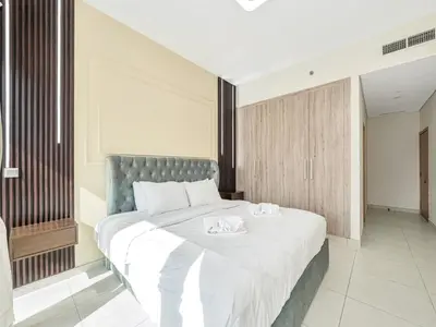 a bedroom with a large bed with two towels on it at Luxury 2BR near Burj Khalifa with Rooftop Pool, City & Canal Views, Free Parking in Dubai