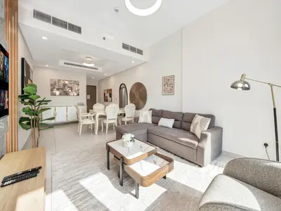 a living room with a couch and a table at Luxury 2BR near Burj Khalifa with Rooftop Pool, City & Canal Views, Free Parking in Dubai