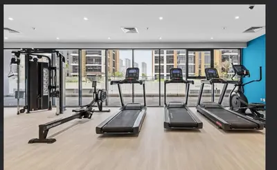 a gym with a row of treadmills at Luxe Studio Vibes Stylish & All New Pet Free in Dubai