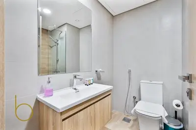 a bathroom with a sink and a toilet and a mirror at Bookable -1 Bed Rukan Townhouse with Clubhouse Access in Dubai