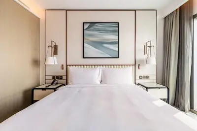 a large white bed in a room with two lamps at Iconic 3BHK I Stunning Creek Views I Sleep up to 6 guests I High Floor I Pool I Free Parking I Pet Friendly I in Dubai