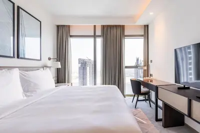 a hotel room with a large bed and a desk at Iconic 3BHK I Stunning Creek Views I Sleep up to 6 guests I High Floor I Pool I Free Parking I Pet Friendly I in Dubai