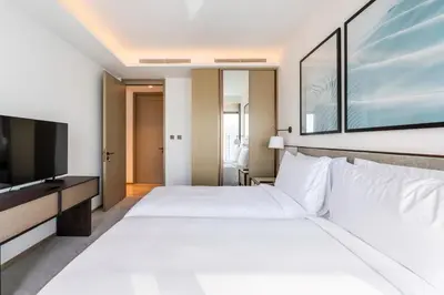 a hotel room with a large bed and a television at Iconic 3BHK I Stunning Creek Views I Sleep up to 6 guests I High Floor I Pool I Free Parking I Pet Friendly I in Dubai
