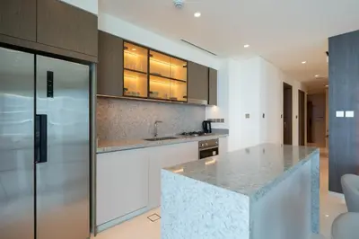 a kitchen with a marble counter top and cabinets at Keyrock - Emaar Beachfront Apartment with Sea & Palm Jumeirah Views in Dubai