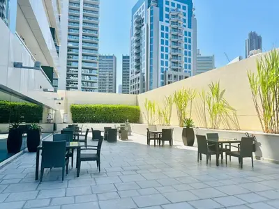 a patio with tables and chairs in a building at Luxurious 1BR , Damac Maison Canal Views in Dubai