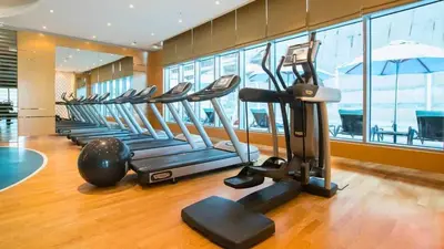 a gym with a row of treadms and a treadmill at TRPS - Maison Mall Street, Downtown - Close to Dubai Mall, Fully Furnished 1BR in Dubai