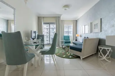 a living room with a dining room table and chairs at TRPS - Maison Mall Street, Downtown - Close to Dubai Mall, Fully Furnished 1BR in Dubai