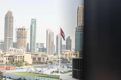 a view of a city with a flag in the foreground at TRPS - Address Opera, Downtown - Burj Khalifa View, Luxury 3BR Living in Dubai
