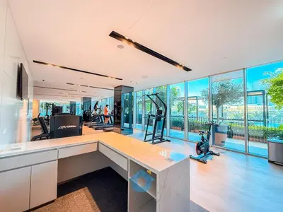 an office with a gym with a desk and windows at Panaromic Burj Khalifa View from Balcony - Luxury 2BR next to Dubai Mall - Like Homes in Dubai