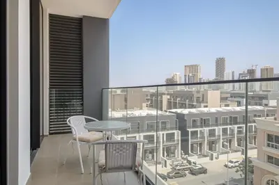 a balcony with a table and chairs and a view of a city at Stylish 1BR in Hamilton House in Dubai