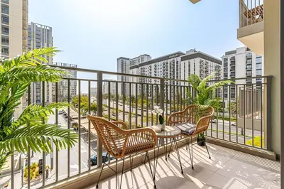 a balcony with two chairs and a table on a balcony at Radiant 2BR APT near Dubai Hills Park & Golf Club in Dubai