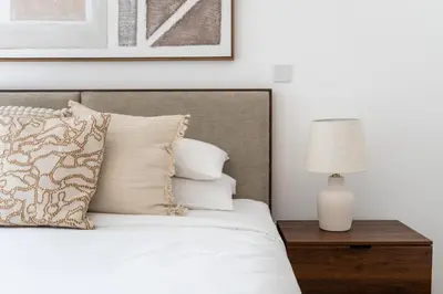 a bedroom with a bed with white sheets and a lamp at GuestReady - Downtown View | 1BR + Sofa Bed in Dubai