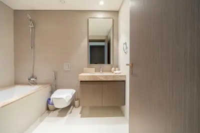 a bathroom with a toilet and a sink and a mirror at KeyRock - Palm View Luxury Stay in Grand Bleu in Dubai