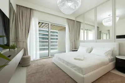 a white bedroom with a white bed and windows at KeyRock - Palm View Luxury Stay in Grand Bleu in Dubai