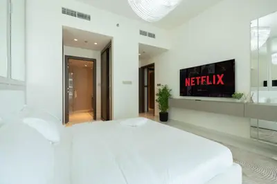 a bedroom with a white bed and a tv on the wall at KeyRock - Palm View Luxury Stay in Grand Bleu in Dubai