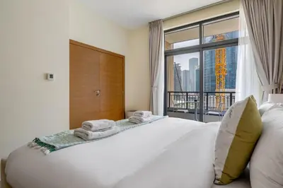 a bedroom with a large white bed with a large window at DAYF-CLA Stylish Apartment for 4 Guests in Central Location in Dubai
