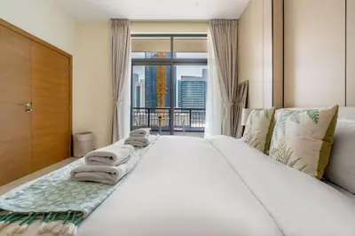 a bedroom with a large bed with towels on it at DAYF-CLA Stylish Apartment for 4 Guests in Central Location in Dubai