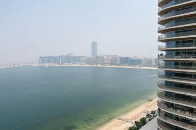 a view of the beach in front of a tall building at KeyRock - Grand Bleu Escape with Iconic Palm Views in Dubai