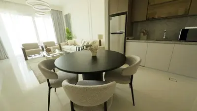 a kitchen and dining room with a table and chairs at Elegant Seaside Luxury 1BR in Beachfront, Grand BLeu Tower, Pool & Gym in Dubai