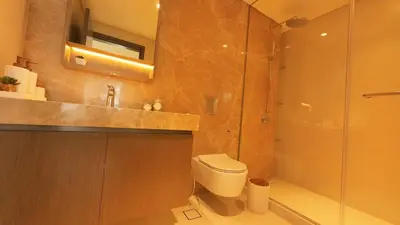 a bathroom with a shower and a toilet and a sink at Elegant Seaside Luxury 1BR in Beachfront, Grand BLeu Tower, Pool & Gym in Dubai
