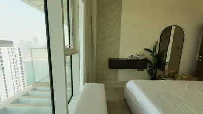 a bedroom with a bed and a balcony with a mirror at Elegant Seaside Luxury 1BR in Beachfront, Grand BLeu Tower, Pool & Gym in Dubai