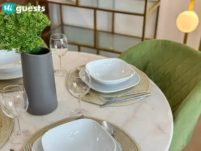 a table with plates and glasses and a vase with a plant at HiGuests - Marina View 1 BR with Spacious Balcony in Dubai