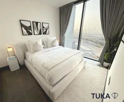 a white bed in a room with a large window at Lux - 2BR - Spacious - Burj Khalifa View - New Bld in Dubai