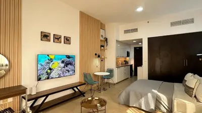 a bedroom with a bed and a tv on a wall at Lovely Studio with balcony in Silicon Oasis in Dubai