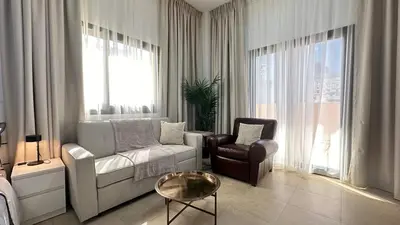 a living room with a couch and a chair at Lovely Studio with balcony in Silicon Oasis in Dubai