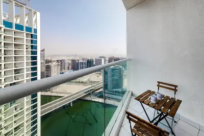 a balcony with two chairs and a view of the city at Studio Apartments with City View at DAMAC Maison Prive in Dubai