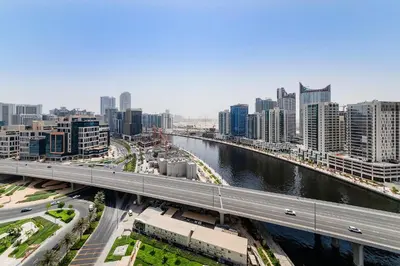 a bridge over a river in a city with buildings at Studio Apartments with City View at DAMAC Maison Prive in Dubai