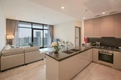 an open kitchen and living room with a couch at Hububb Luxury Peninsula 5 Dubai in Dubai