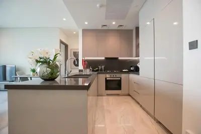 a kitchen with a vase of flowers on a counter at Hububb Luxury Peninsula 5 Dubai in Dubai